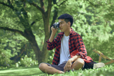 Full length of young man sitting outdoors