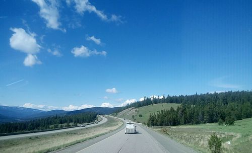 Country road along landscape and against blue sky