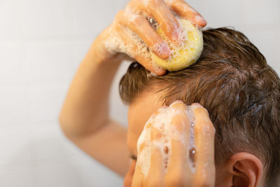 A man uses a solid shampoo bar in the bathroom. sustainable hair care. responsibility for the nature