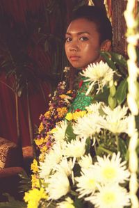 Portrait of woman standing amidst flowers 