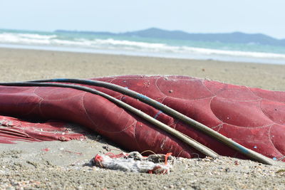 Close-up of red umbrella on beach