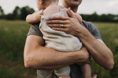 Father with baby son standing in garden