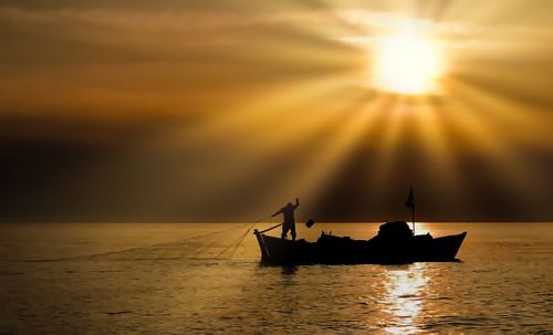 Silhouette sailboat on sea against sky during sunset