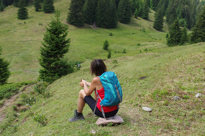 Rear view of woman sitting on grassy field