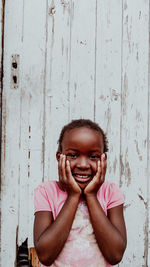 Portrait of young woman standing against wall