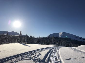 Scenic view of snow covered mountains against bright sky