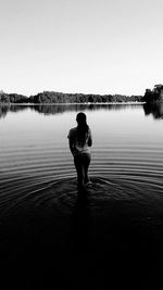 Silhouette of woman standing by lake