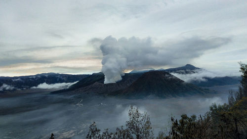 Smoke emitting from volcanic mountain against sky