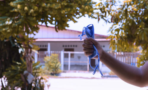 Person holding umbrella against trees