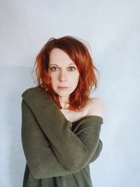 Portrait of beautiful young woman against white background