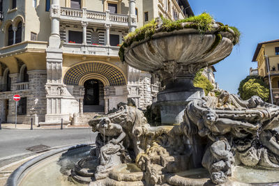 Statue against fountain in city