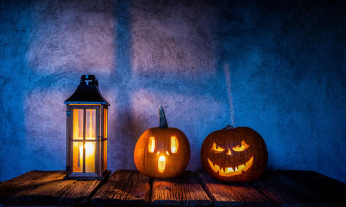 Close-up of illuminated jack o lantern against wall