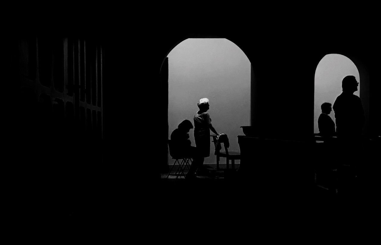 SILHOUETTE PEOPLE STANDING IN CORRIDOR OF BUILDING