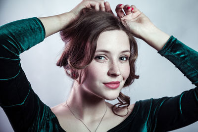 Portrait of smiling young woman drinking water at home