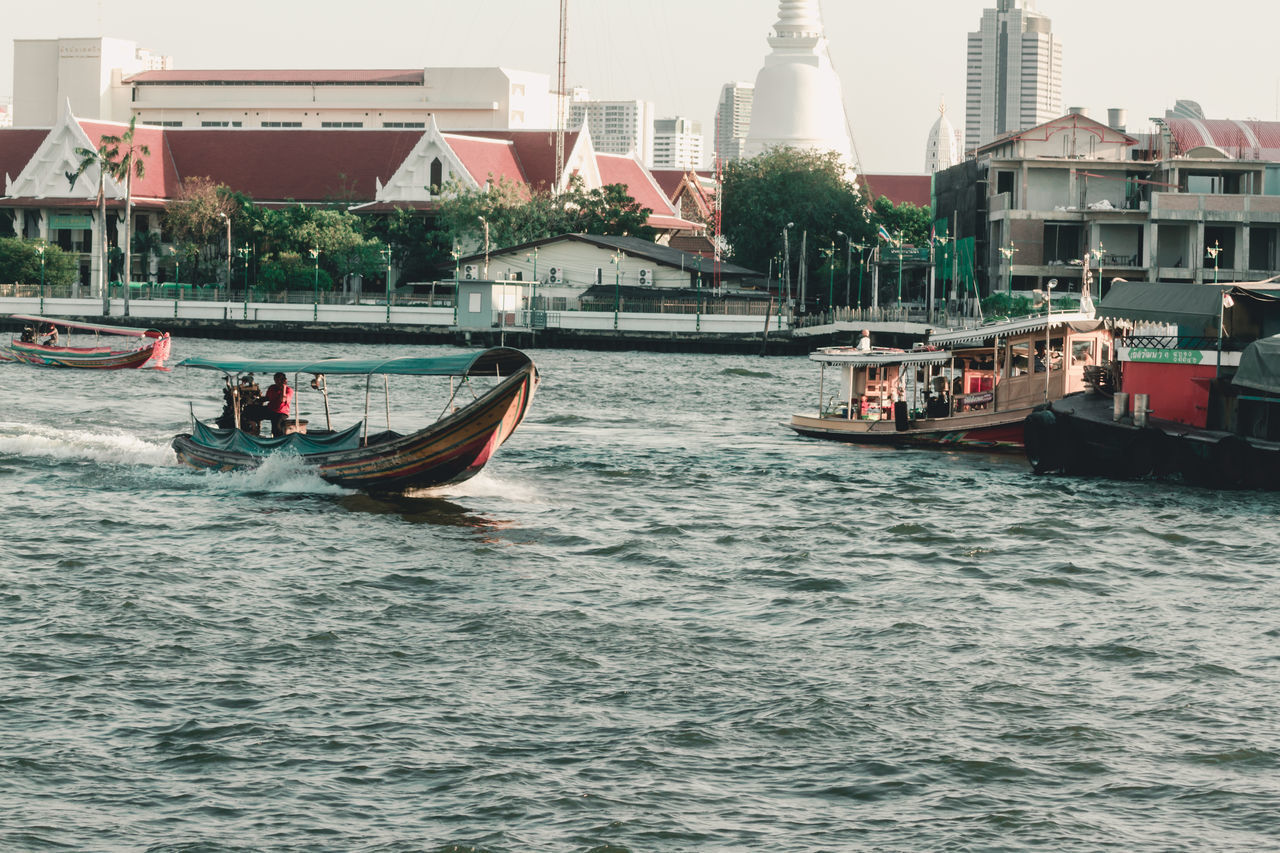 BOATS IN CANAL BY BUILDINGS IN CITY