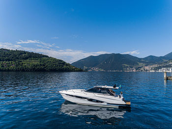 Sailboats moored on lake against blue sky