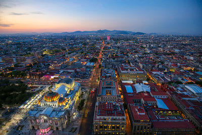 High angle view of illuminated buildings in city at dusk