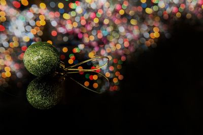 Close-up of bauble against colorful lights