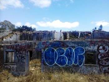 Graffiti on abandoned building against sky