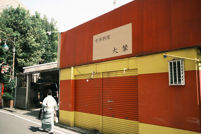 Rear view of people walking on building in city