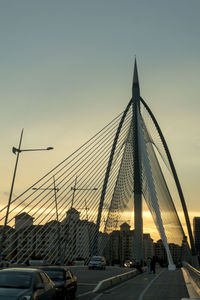 Suspension bridge in city against clear sky