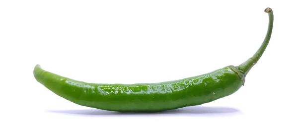 Close-up of green chili pepper against white background