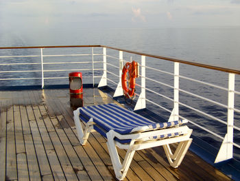 Lounge chairs on boat deck in sea