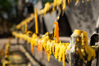 Close-up of yellow bell hanging outside temple