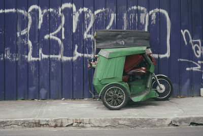 Bicycle parked on street against wall