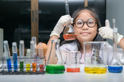 Portrait of girl gesturing while holding chemical