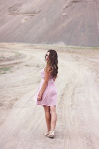 Portrait of woman standing on dirt road