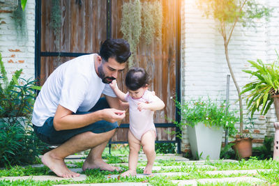 Couple kissing while standing against plants