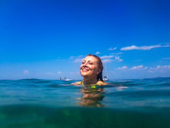 Portrait of smiling young woman swimming in pool