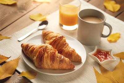 Breakfast with cup of coffee, croissants, jam, fresh orange juice