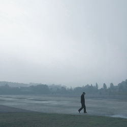 Man standing on field against sky
