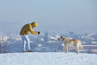 Dog standing on snow covered landscape during winter