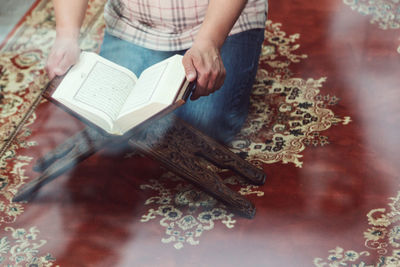 Low section of woman reading book