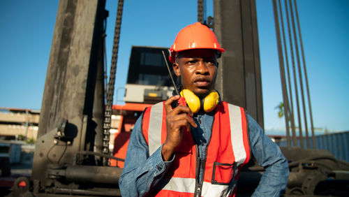 Portrait of young man standing against building