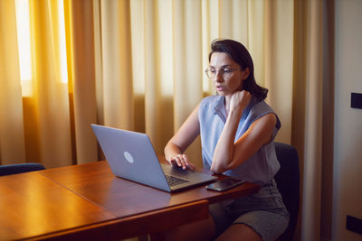 Young woman using laptop at table