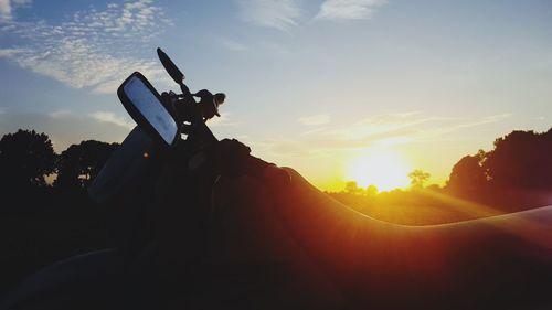 Close-up of silhouette camera against sky during sunset
