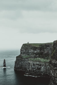 Rock formations by sea against sky