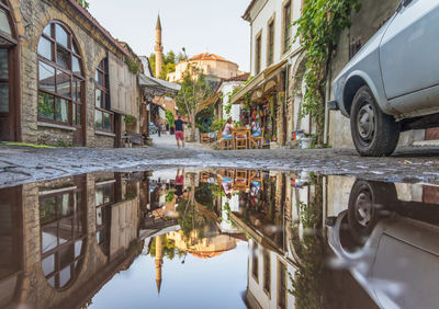 Reflection of building in puddle on street