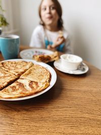 Portrait of young woman having breakfast on table