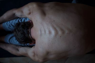 Directly above shot of shirtless man stretching at home