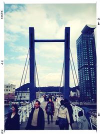 People in city against cloudy sky