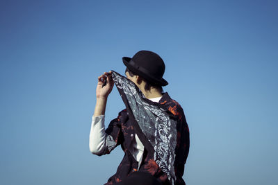 Woman wearing hat against blue sky