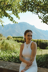 Portrait of young woman standing against sky