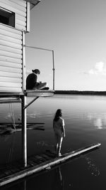 Girl standing on pier by lake