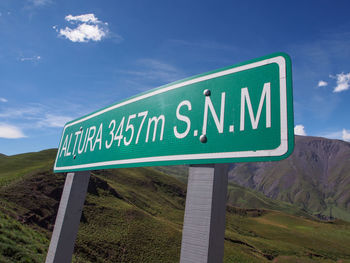Information sign on road against sky
