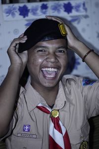 Portrait of young man standing against wall